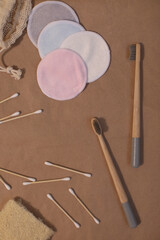 plastic free and eco friendly products in household, wooden toothbrushes, cotton swabs on craft paper background top view 