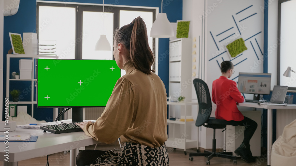 Poster employee working with green screen on computer in business office. woman worker using chroma key cop