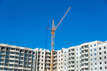 Fototapeta na wymiar Construction cranes and new multistorey houses