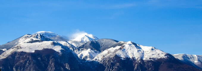 snowy mountain top before snowfall with wind blowing snow. Banner