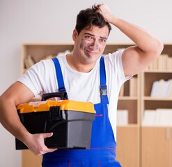 Funny worker with dirty face and toolkit