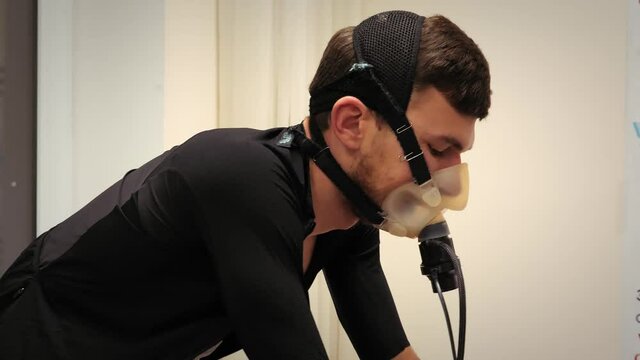 Professional athlete measuring heart rate in medical science lab. Cyclist doing Vo2 Max test
