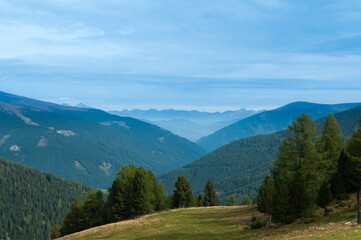 Naklejka premium Bergige Landschaft in Österreich. Blick von einem hochgelegenen Punkt auf eine Gebirgskette. Sonniger Herbsttag