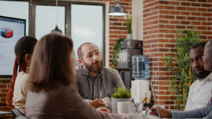 Close up of business man discussing strategy plan with people at briefing meeting. Worker explaining project design to create financial presentation for company development and growth.