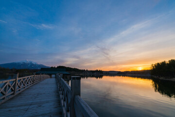Obraz premium 青森の長い木造橋と池のリフレクションと夕焼け