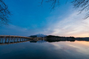 青森の長い木造橋と池のリフレクション
