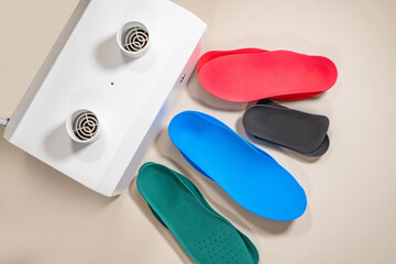 Orthopedic insoles for shoes on a colour background. Foot care
