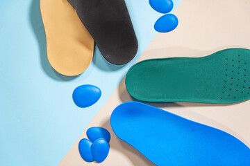 Orthopedic insoles for shoes on a colour background. Foot care