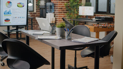 Nobody in business office decorated for work meeting with people. Empty startup space with computer to plan marketing project and strategy, boardroom with pc on desk and decorations.