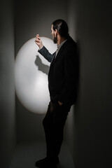 playing with shadows. click gesture. circle spotlight artistic mood concept. young elegant man in...