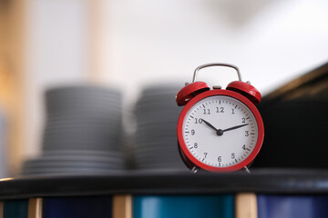 Red alarm clock on the kitchen table, close-up