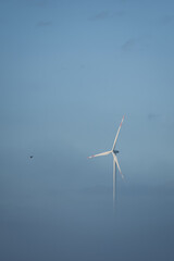 Windmill in foggy landscape. Renewable energy for environmentally conscious future