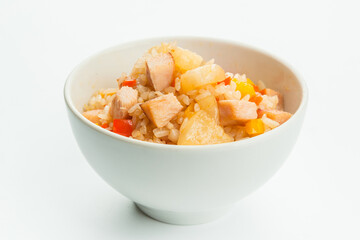 Asian meat rice with chicken fillet, ananas (pineapple), bell pepper, onion, carrot and served in white bowl. Stir fry Dish isolated on white background. Copy space image
