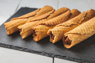 Wafer rolls with condensed milk. Thin and Crispy Waffle. Selective focus