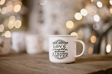A cup of coffe with christmas tree lights bokeh as background. Holiday season coffee break.