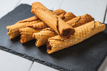 Wafer rolls with condensed milk. Thin and Crispy Waffle. Selective focus