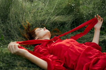 woman in red dress lying on the grass fresh air nature romance