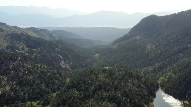 survol d'un lac de montagne et des forets dans les Pyr&eacute;n&eacute;es-Orientales, sud de la France, parc naturel des Bouillouses	