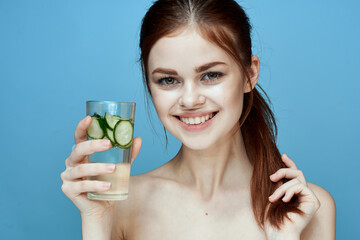 woman with bared shoulders cucumber health drink blue background