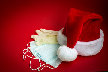 Santa Claus hat, medical masks and gloves. Safe greetings for Christmas and New Year. Copy space. - 473021903