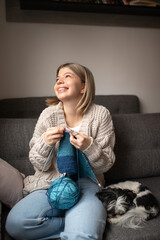 Young woman knitting while relaxing at home