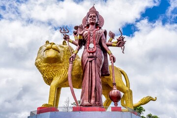 A powerful Statue of the Hindu goddess Durga Maa with a golden lion in sacred Ganga Talao. Grand...