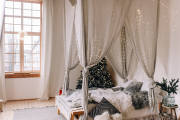 Bright bedroom with Christmas decor and a Christmas tree