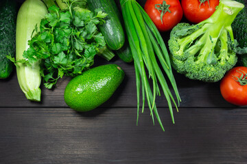 Fresh organic vegetables on a dark wooden background with space for text. Top view. Concept of healthy, vegetarian, diet food.