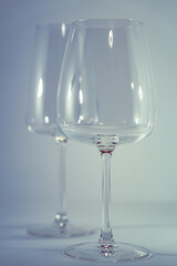 vasos de cristal sobre fondo blanco con reflejos, de vino blanco y vino tinto 