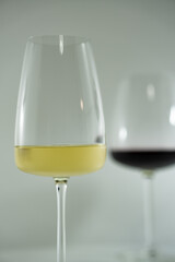 vasos de cristal sobre fondo blanco con reflejos, de vino blanco y vino tinto 
