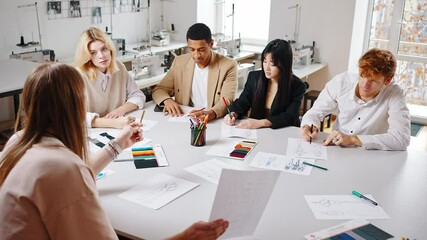 Diverse creative team discussing new project, sitting together at conference room, creating new fashion collection - Powered by Adobe