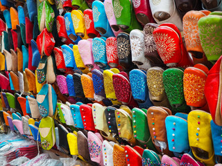 Handmade colourful babouche - leather slippers on display at traditional souk - street market in Morocco