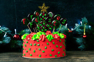 Christmas cake with balls with an inscription in German Frohes Fest Happy holidaya. Decoration for the holiday. Low key.