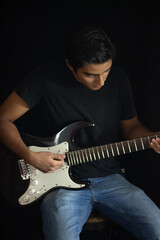 Obraz premium boy playing electric guitar inside a studio
