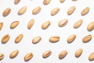 Obraz premium Roasted pistachio nuts pattern on white. Whole fried and dried pistachio nut