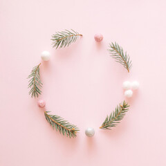Christmas frame made of christmas items. Pink aesthetic background.