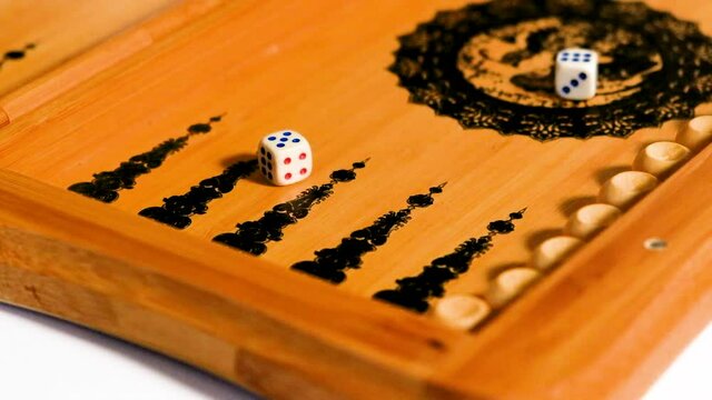 The dice fall onto the backgammon board, six, five.