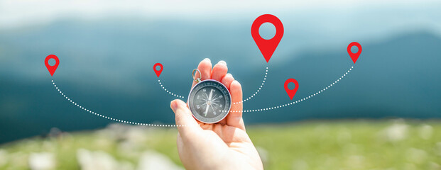 Traveler holding compass in hand for searching direction outdoor. Person use compass to find location - obrazy, fototapety, plakaty