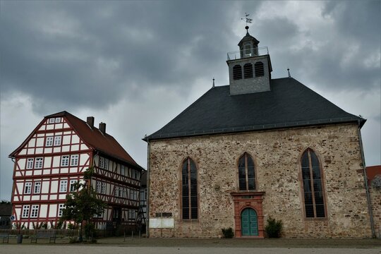 Evangelische Schlosskirche und Fachwerkhaus mit dunklem Himmel am Paradeplatz in Schwalmstadt-Ziegenhain