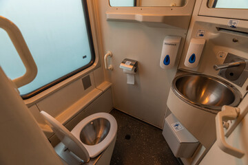 Toilet room with wash basin and mirror in expres train in cold winter day