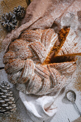 Сut bundt cake  or panettone cake decorated icing sugar. Sieving powdered sugar on a Christmas cake and cones. Shallow depth of field