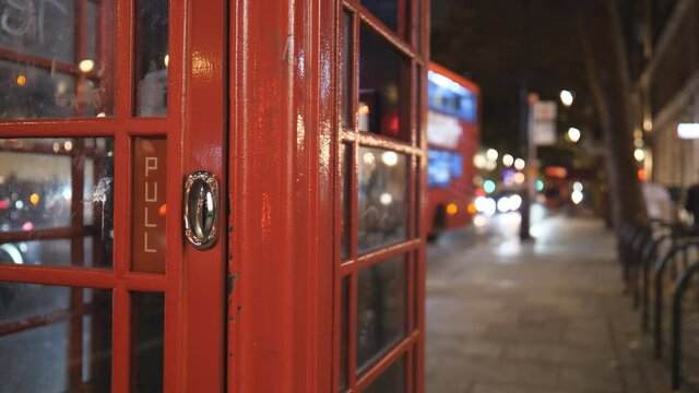 A close up view of a red telephone booth in London at night.
