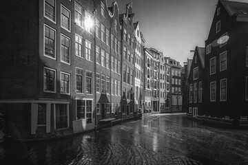 Fototapeta premium Windows in the rays of the sun on old houses in the center of Amsterdam in black and white.