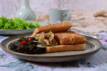 Breakfast on a plate:
breaded fried cheese, beetroot puree, fried onions, toast. Linen tablecloth crocheted. Lettuce leaves on a plate.