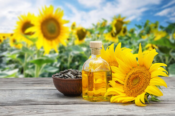 Sunflower oil with flowers and sunflower seeds on a wooden table