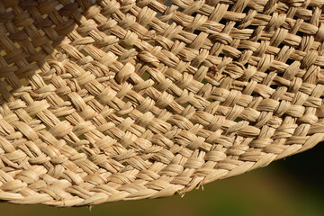 Close up and texture, detail of an old straw hat with the braided fibers
