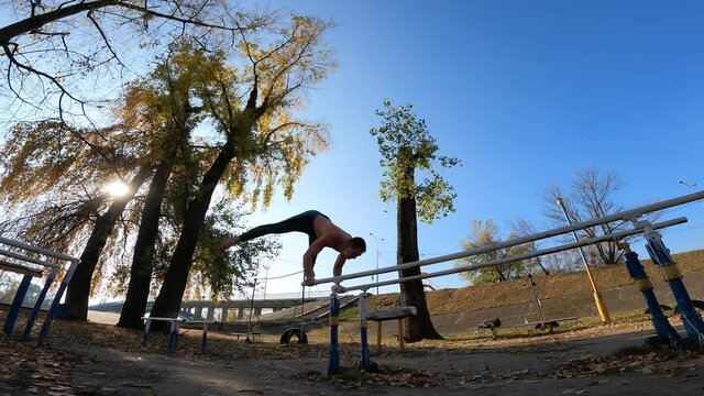 Gymnast does tricks on parallel bars outdoor. Concept of willpower, motivation and passion