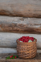 basket with raspberries on a wooden background