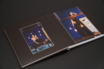 open photobook from a photo shoot of an attractive woman on a black background. 