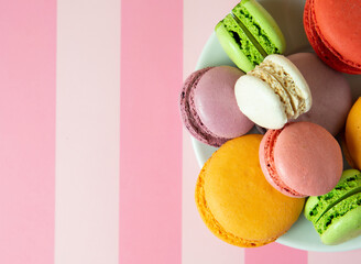 Fresh baked colored macaroon cookies macarons, macarons on a white plate close-up,